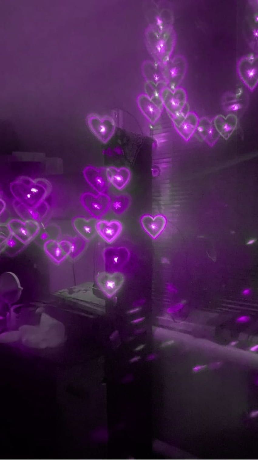 A dark room with purple lights shaped like hearts. - Lovecore