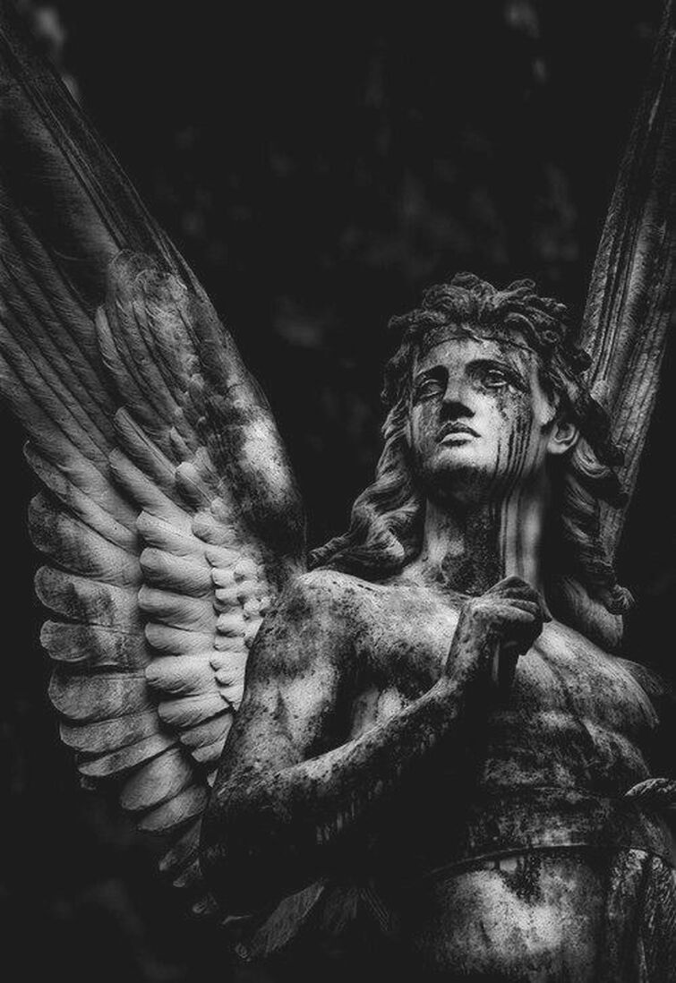 A sculpture of a winged angel holding a heart. - Angelcore