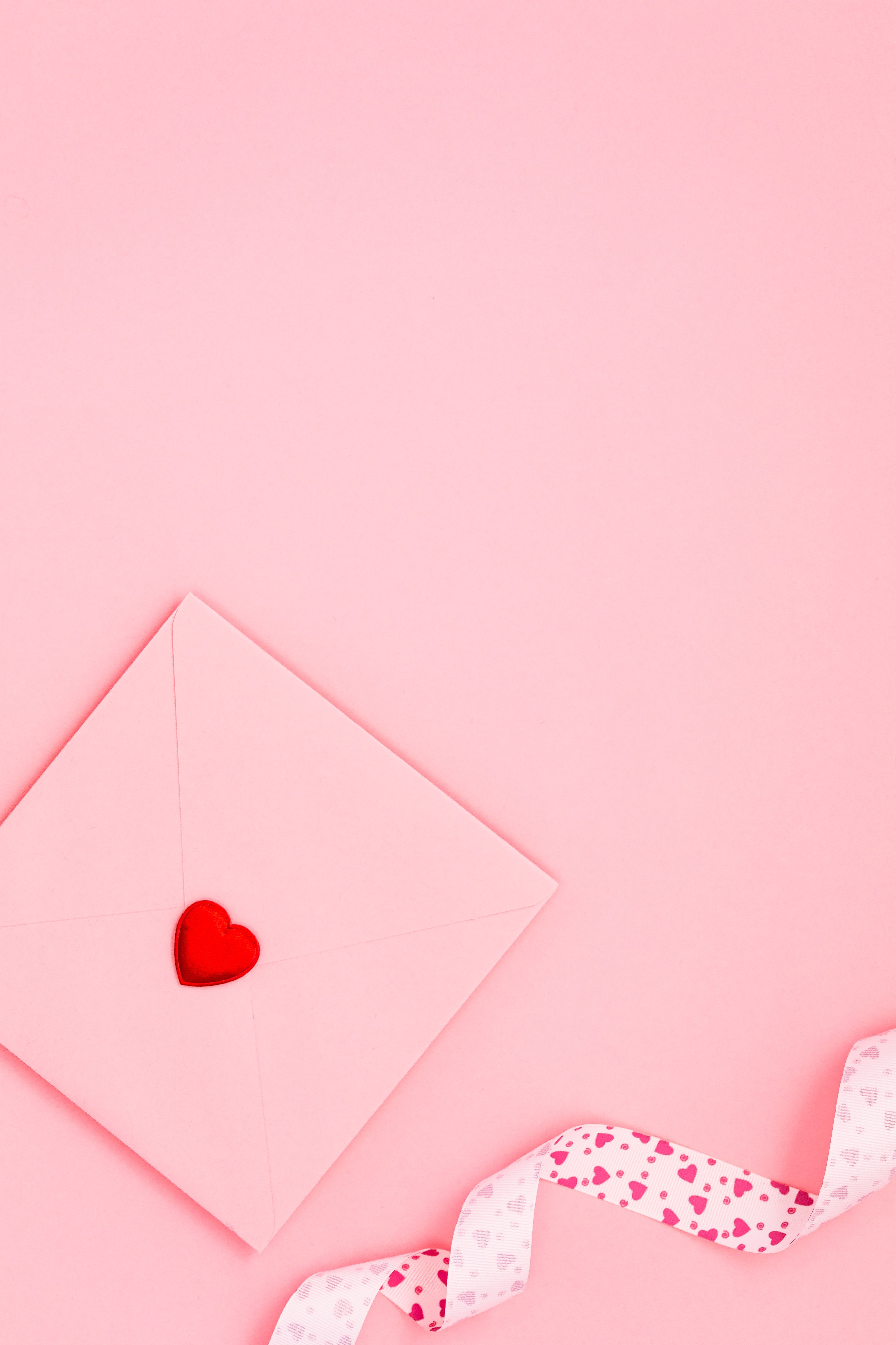 A pink envelope with red heart on it and ribbon - Lovecore