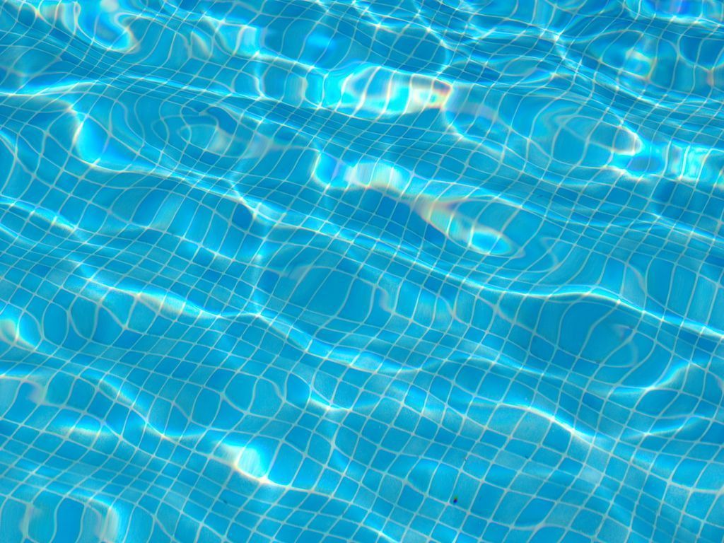 A pool with blue water and white tiles. - Swimming pool