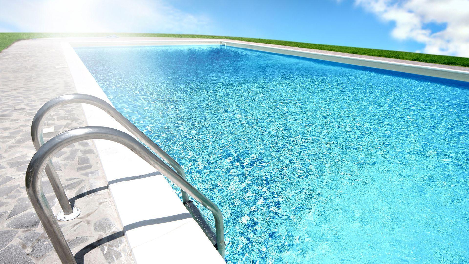 A swimming pool with a ladder and a blue sky - Swimming pool