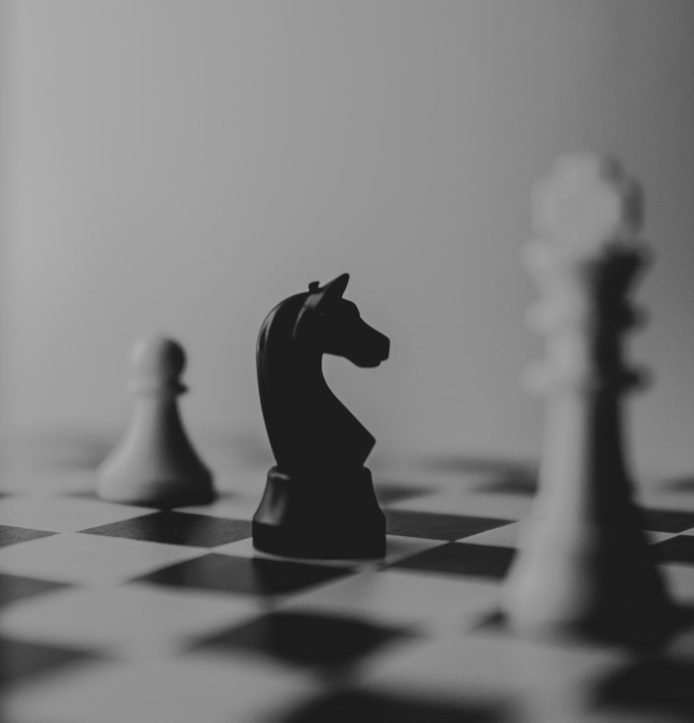 A black and white photo of chess pieces - Chess