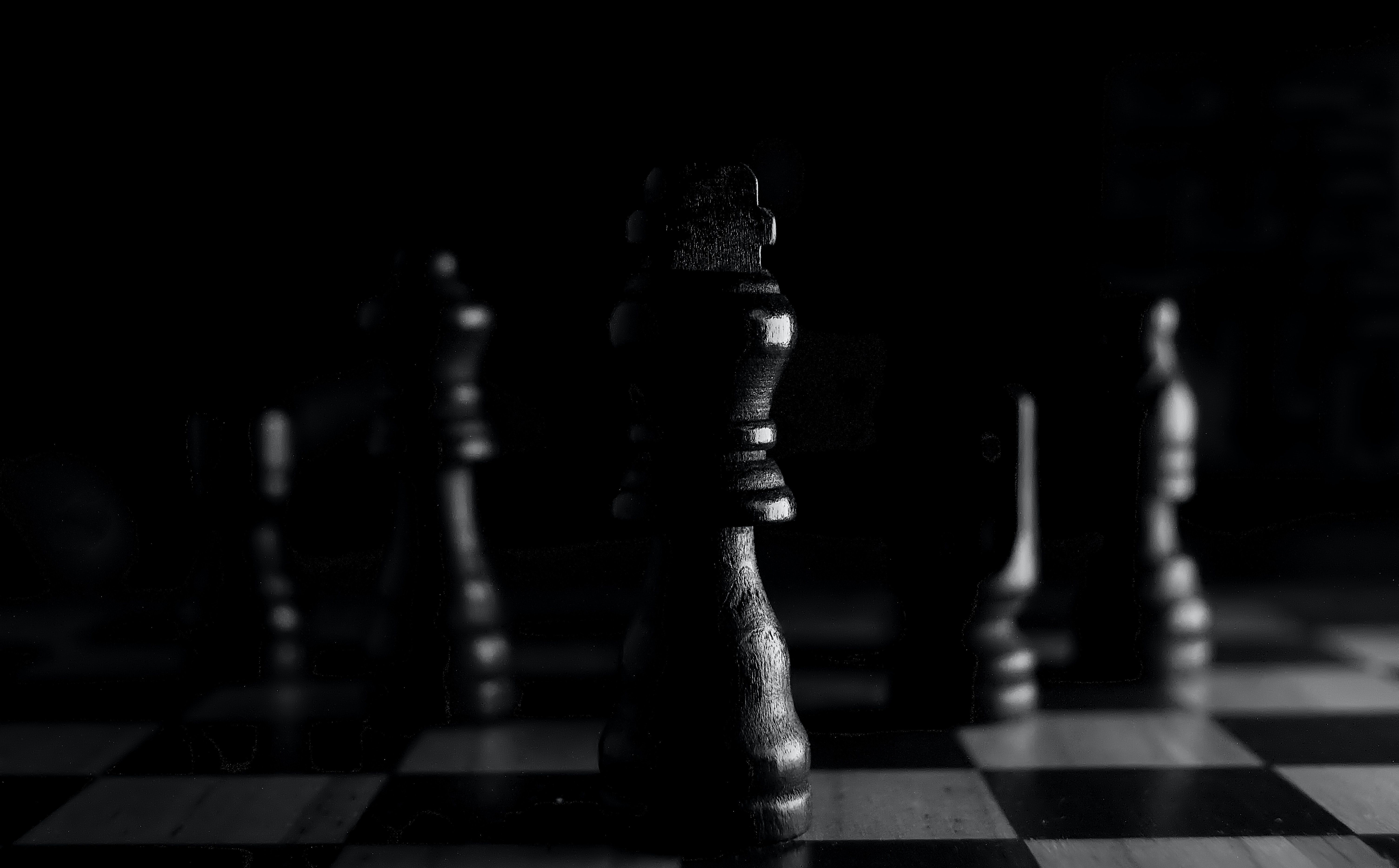 A black and white photo of a chess board with a black king in the center. - Chess