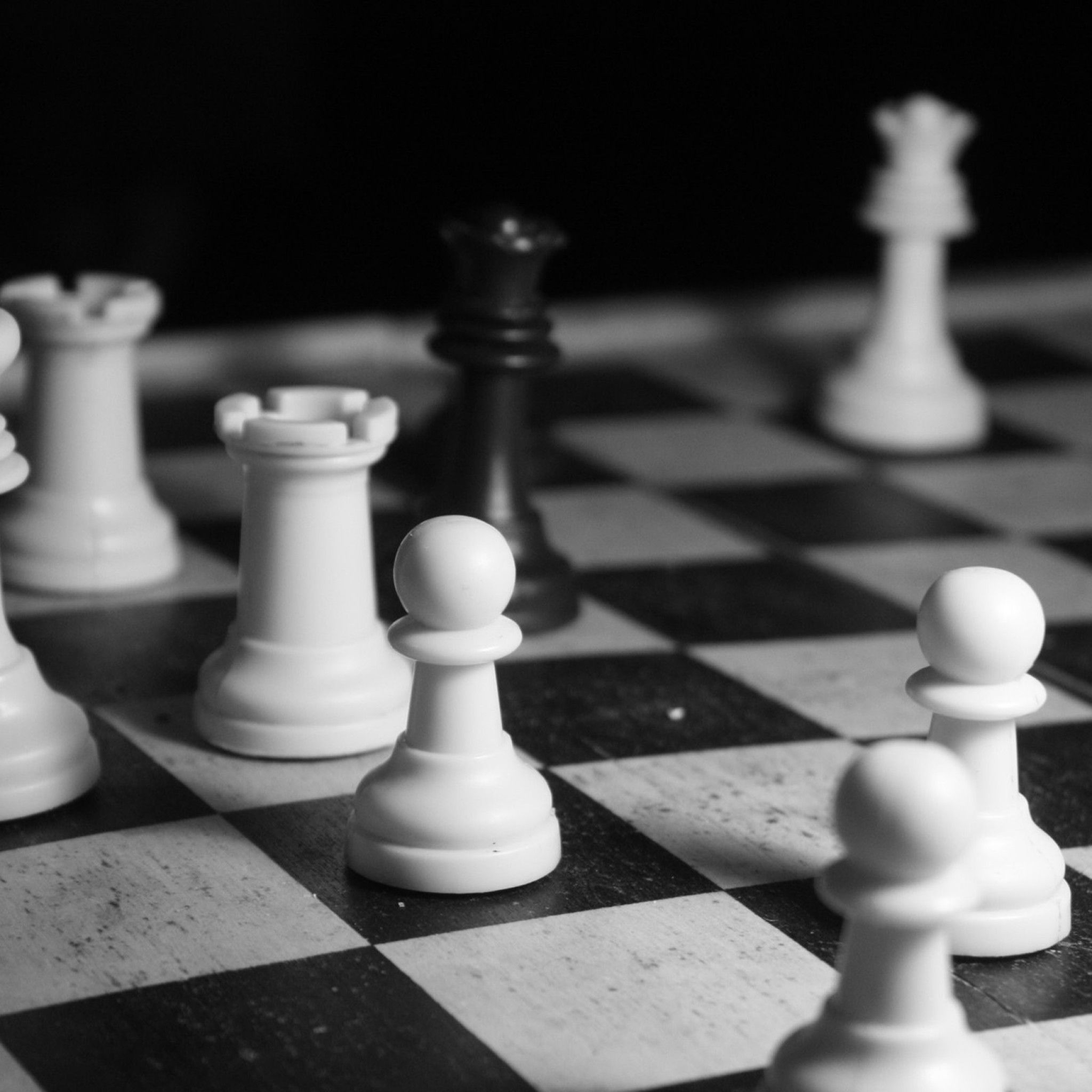 A black and white chess board with a black pawn in the center - Chess