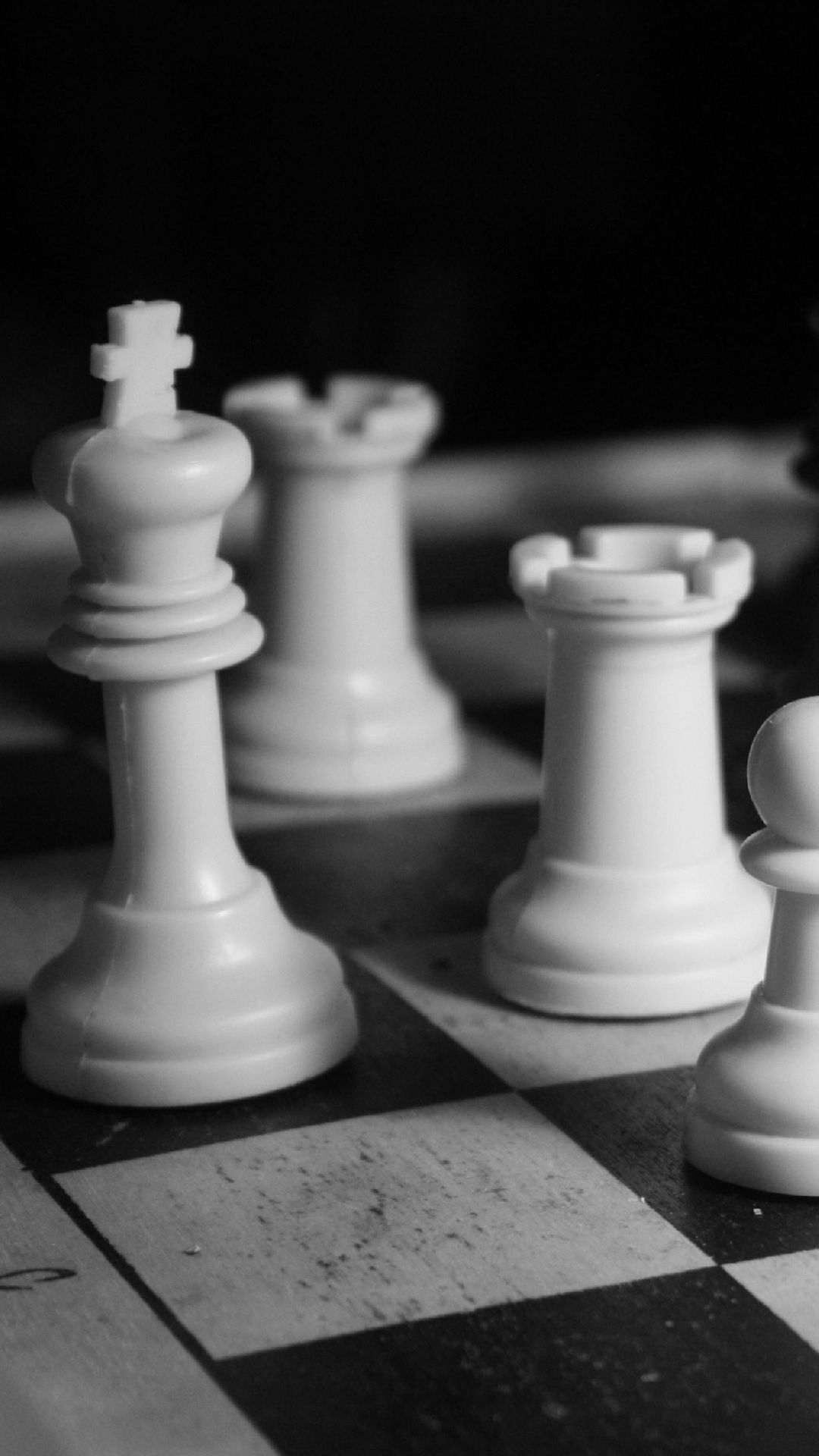 Black and white photo of a chess board with a black and white king and queen in the center - Chess