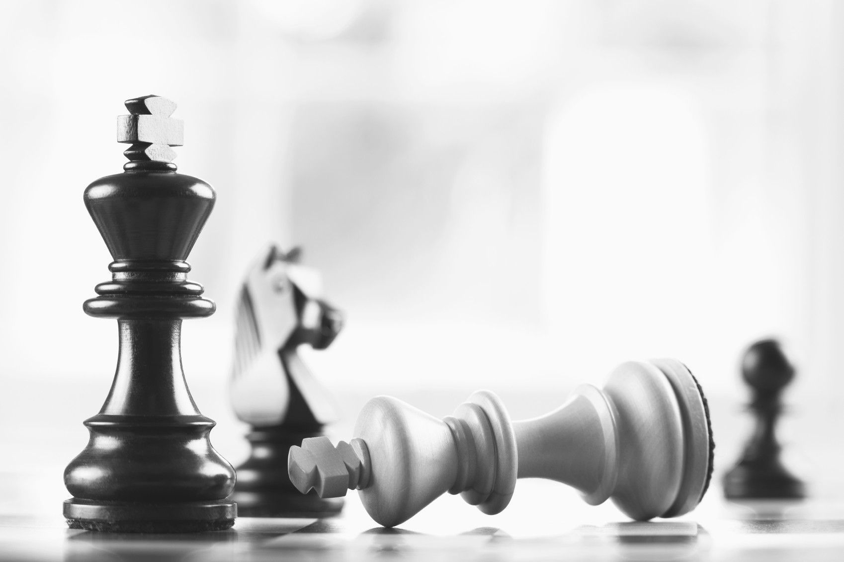 A black and white photo of chess pieces on the board - Chess