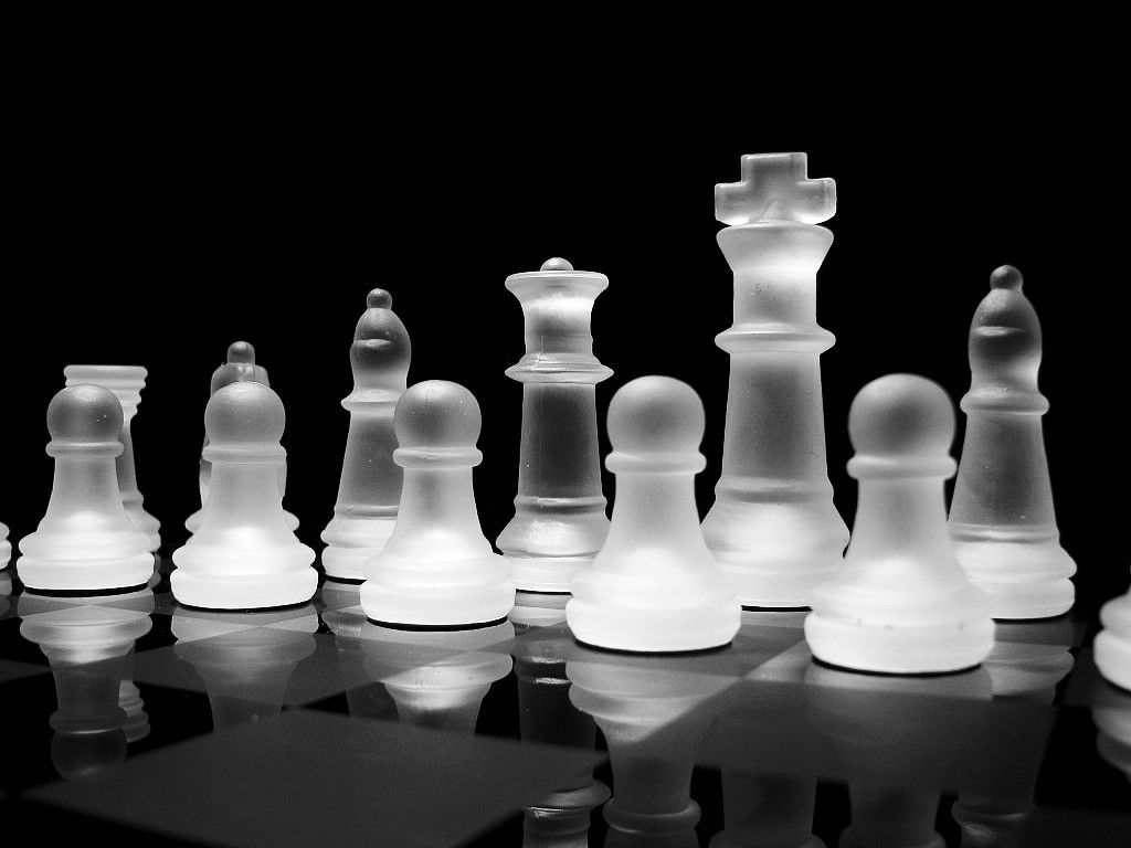 Black and white photo of a chess board with glass chess pieces - Chess