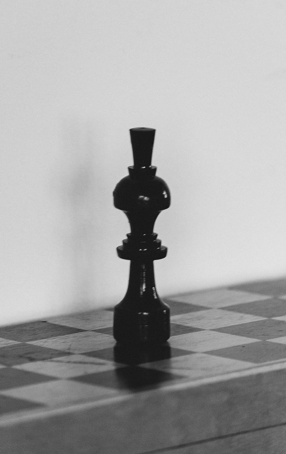 A black chess piece sitting on top of the board - Chess