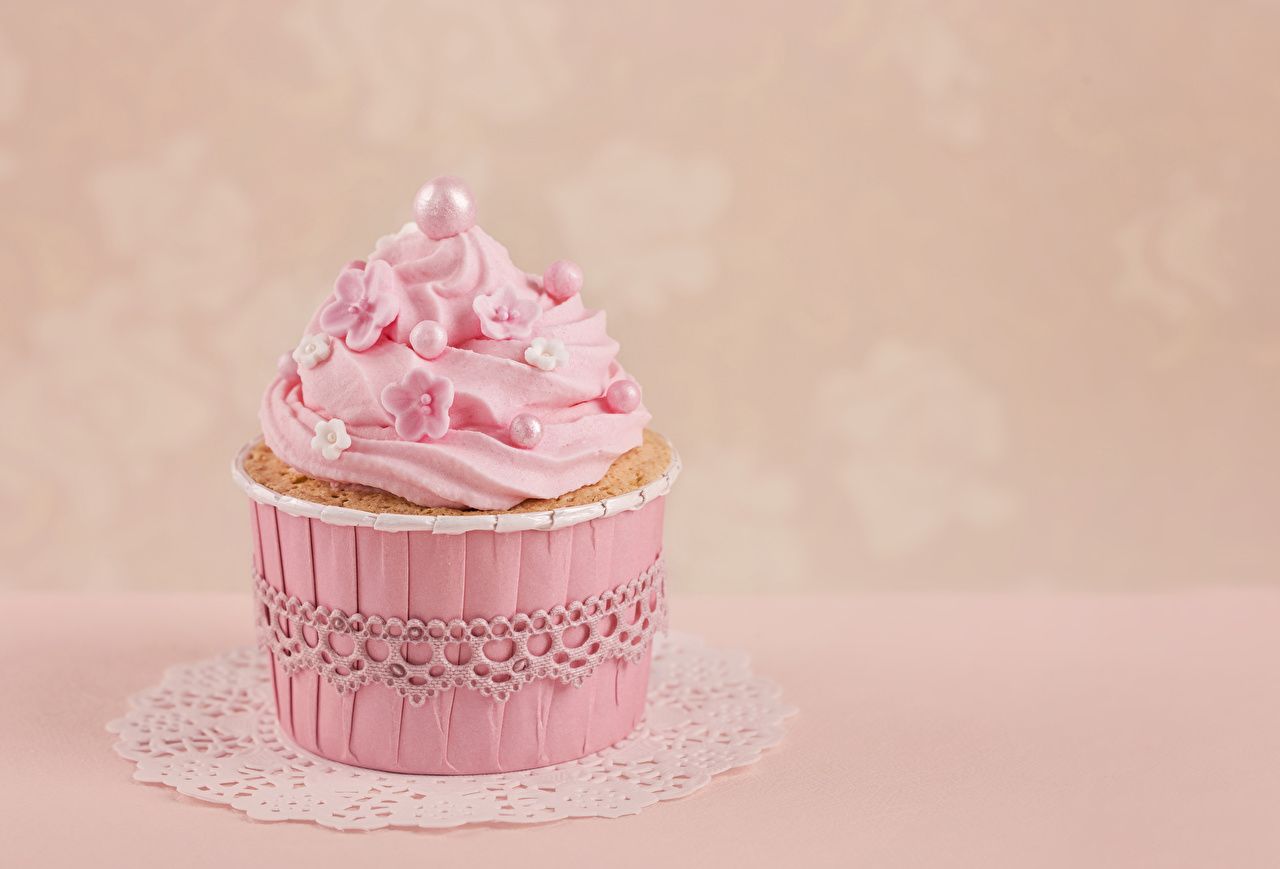 A pink cupcake with pink frosting and a pearl on top - Cake