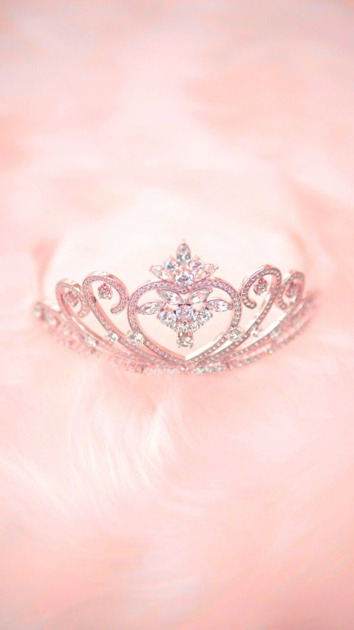A crown is sitting on top of some pink fabric - Crown