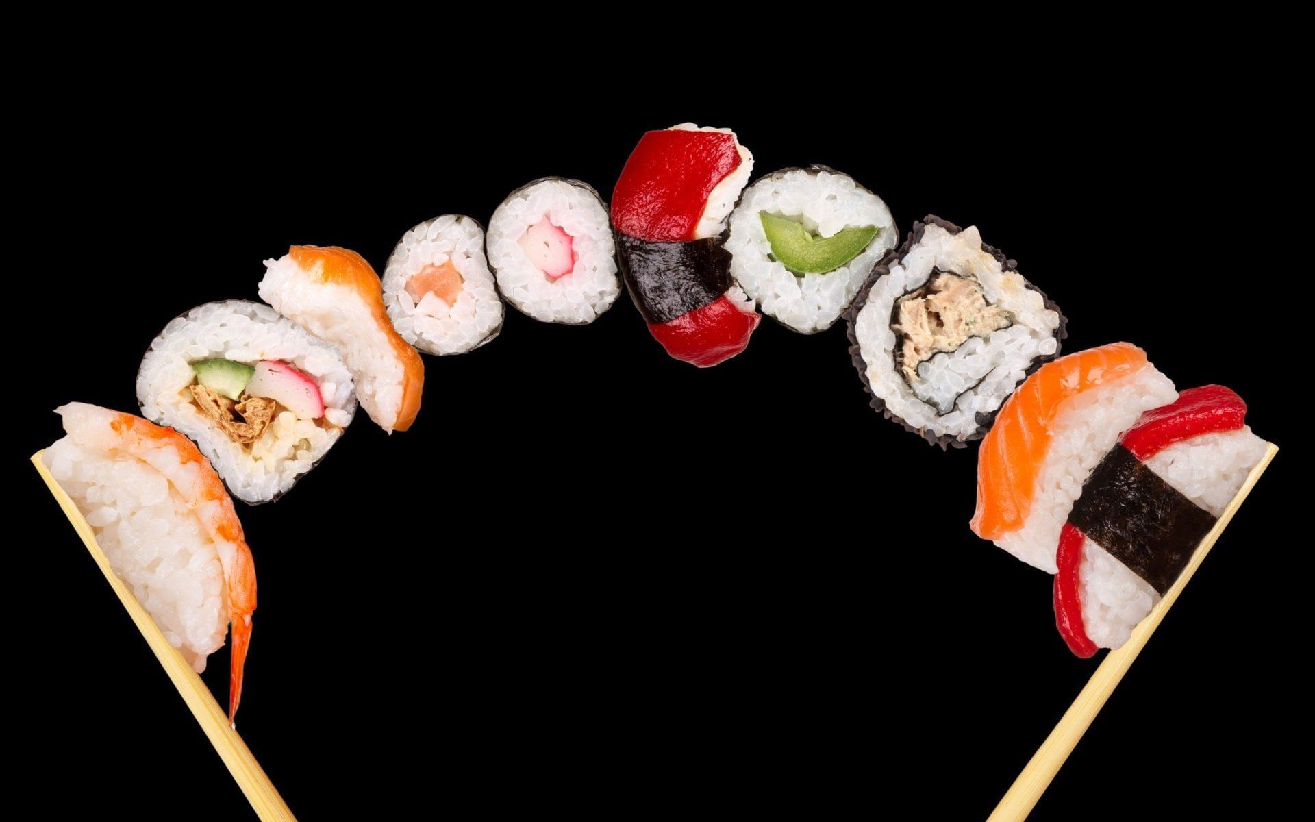 Sushi rolls with chopsticks on a black background - Sushi