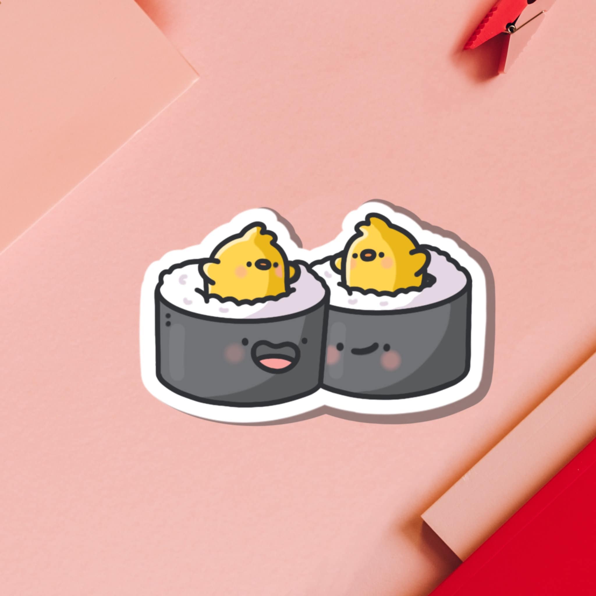 A sticker of two pieces of sushi on a pink background - Sushi