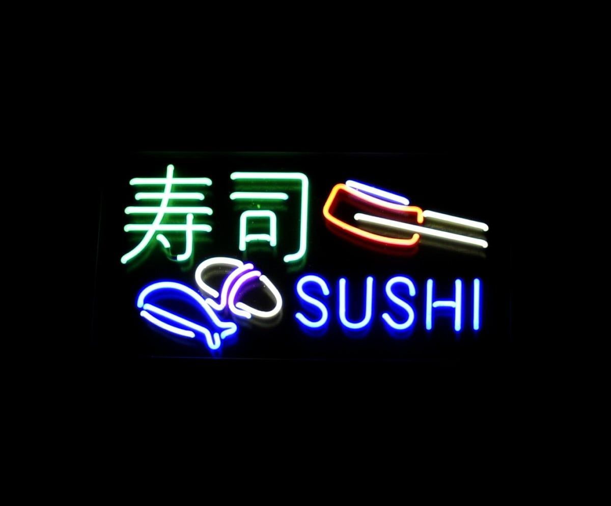 A neon sign that says Sushi in blue, white, and green letters. - Sushi