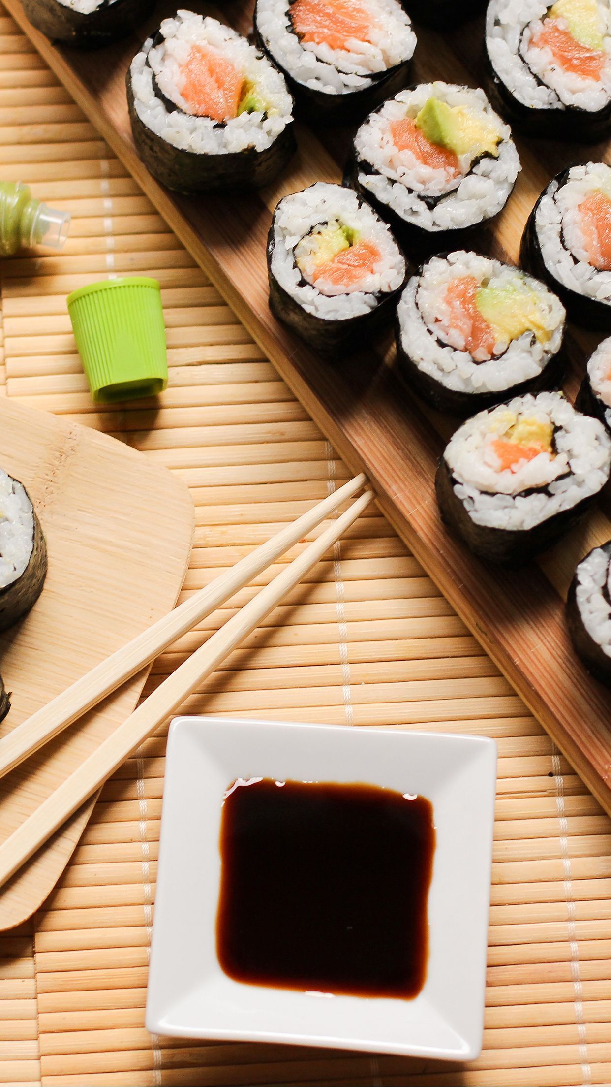 Sushi on a wooden board with soy sauce and chopsticks. - Sushi