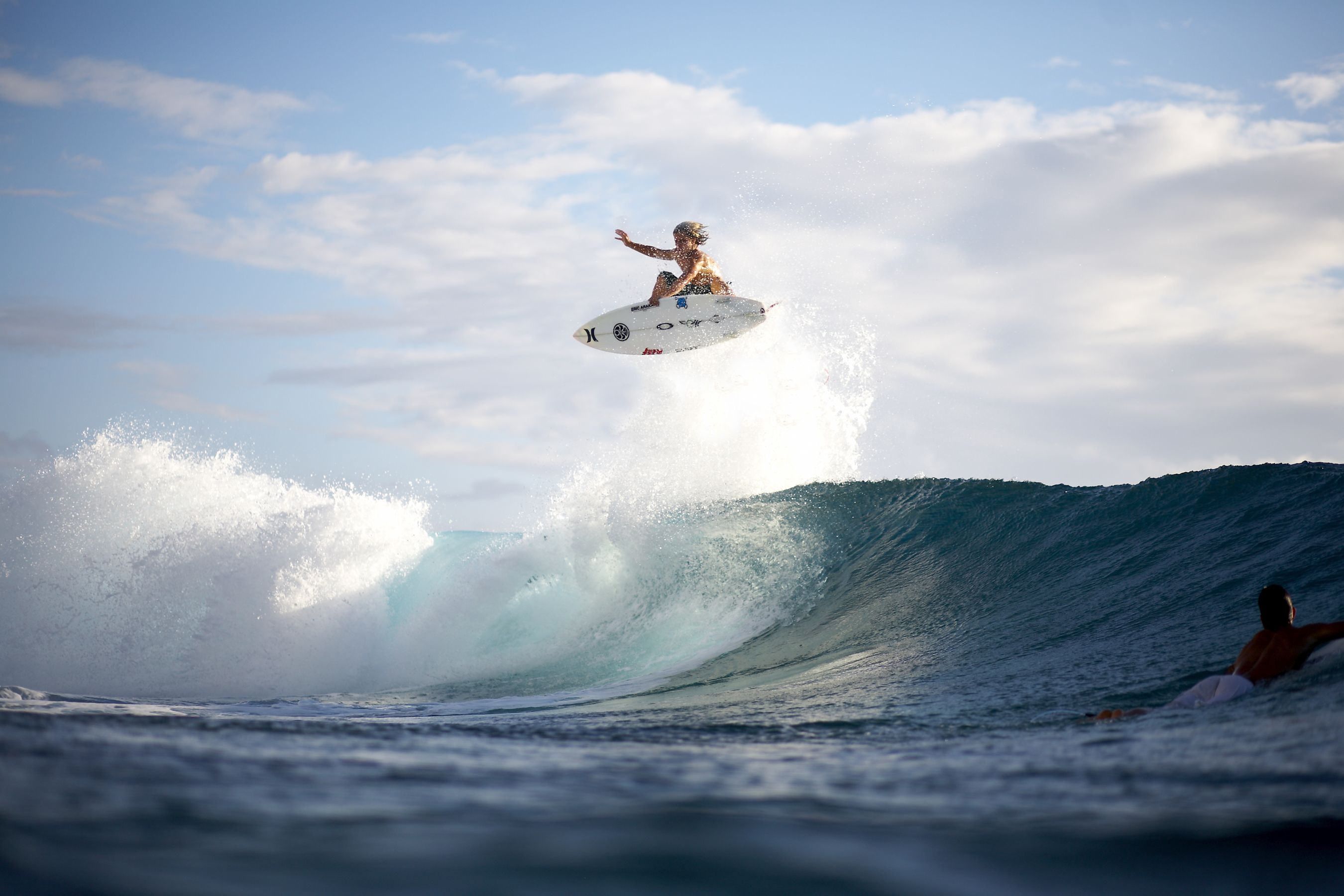 A surfer is in mid air after jumping off a wave. - Surf