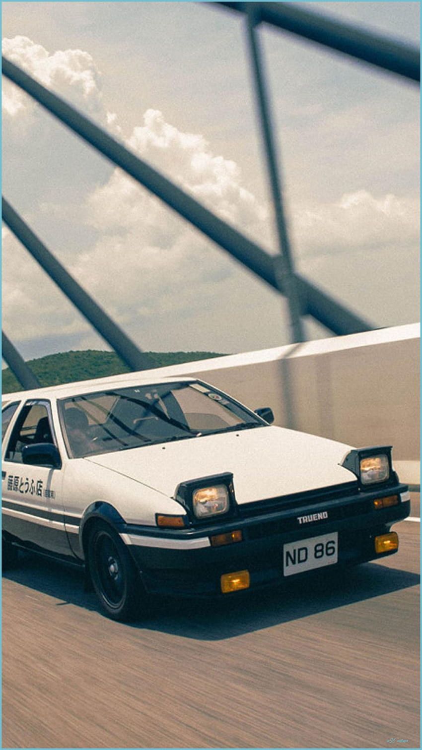 A white car with the license plate ND 86 is driving on a road. - Toyota AE86