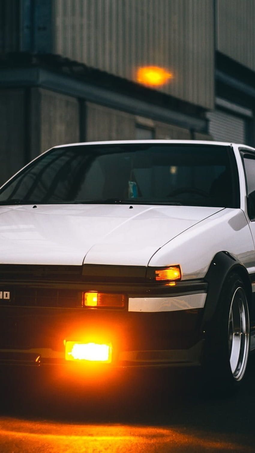 A white car with orange lights on. - Toyota AE86