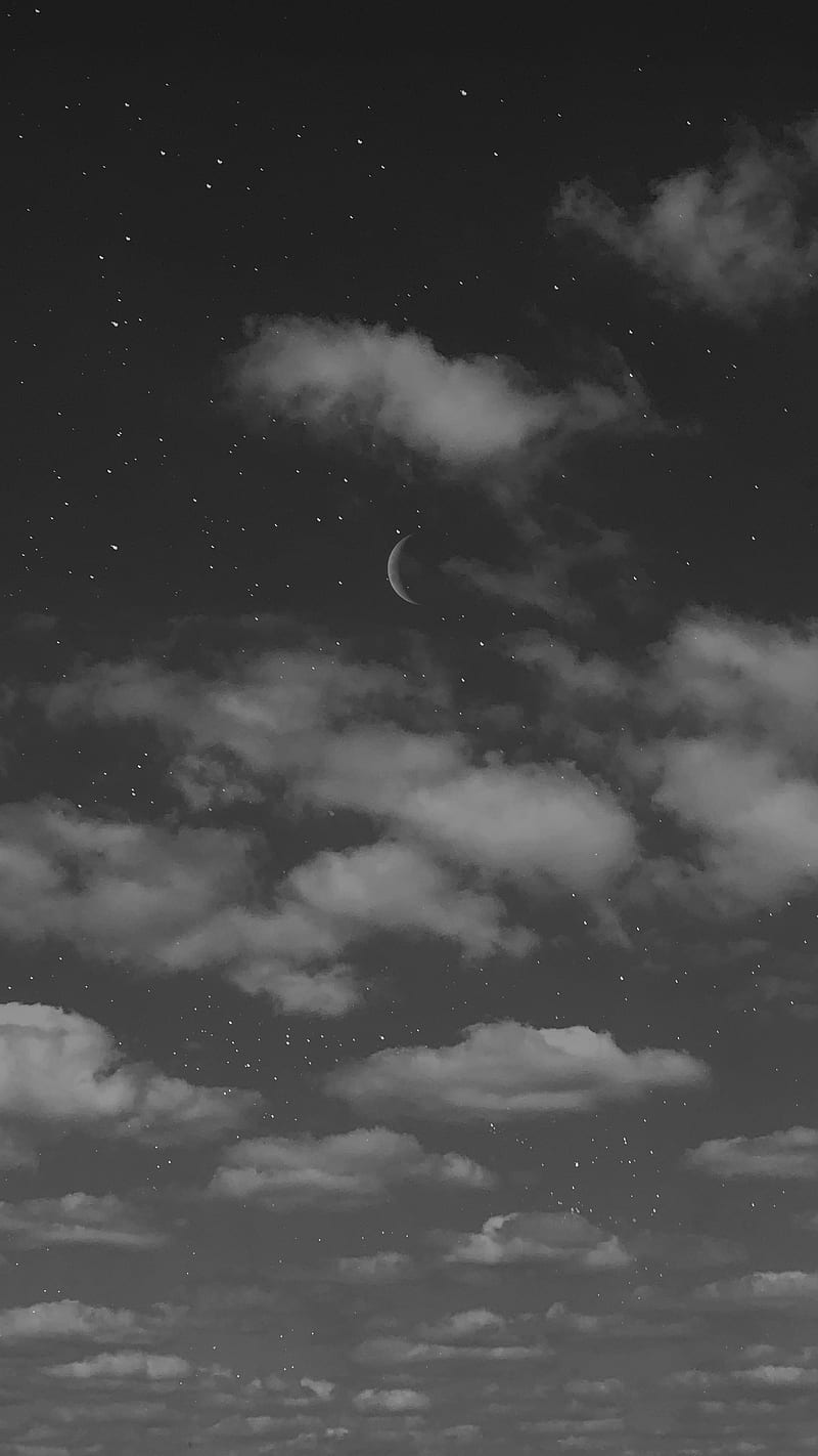 A black and white photo of the night sky with a crescent moon and stars. - Black and white