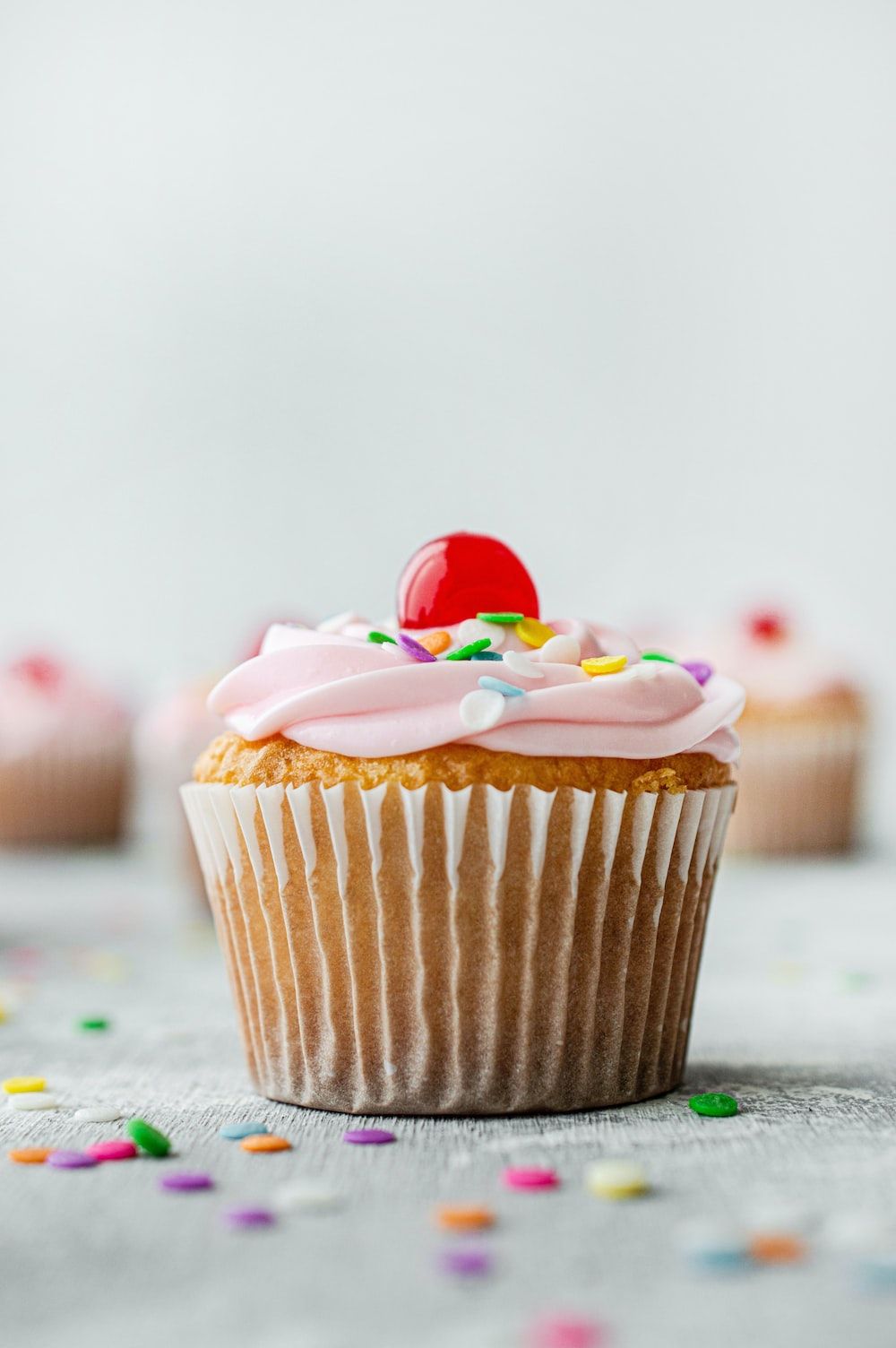 A cupcake with pink frosting and sprinles - Cupcakes