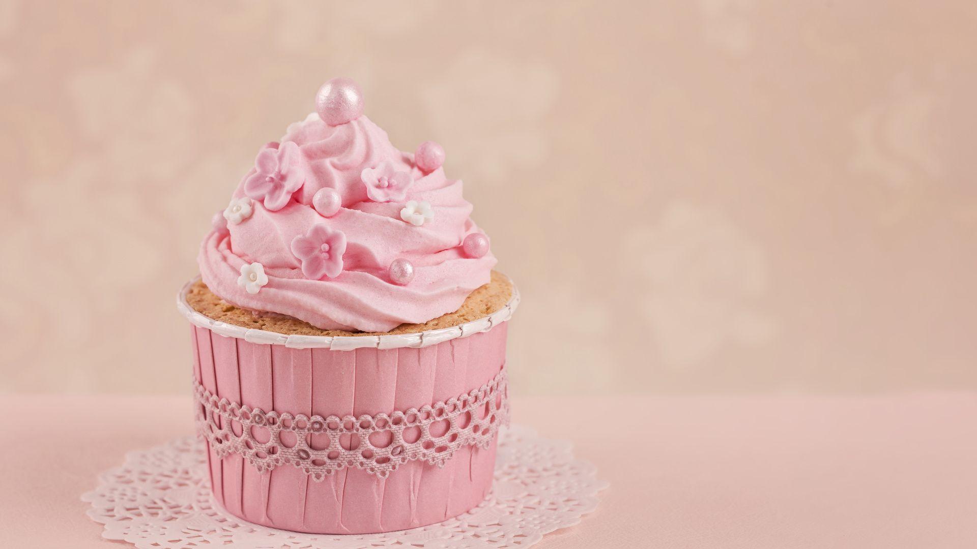 A pink cupcake with pink frosting on a pink background - Cupcakes