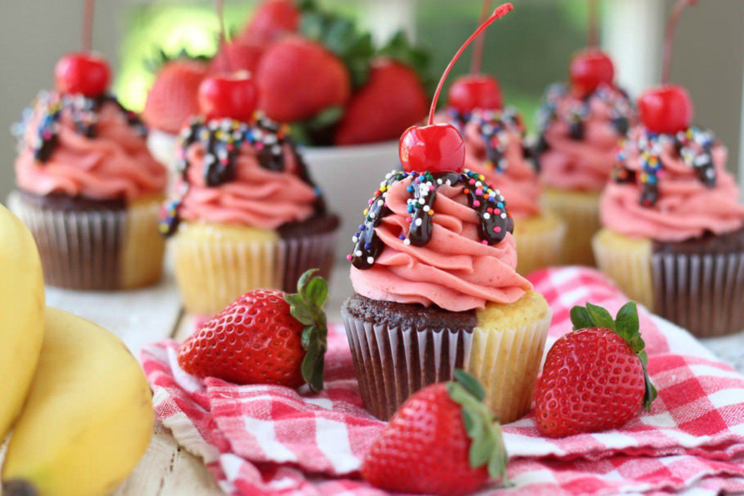Chocolate cupcakes with strawberry frosting and a cherry on top. - Cupcakes