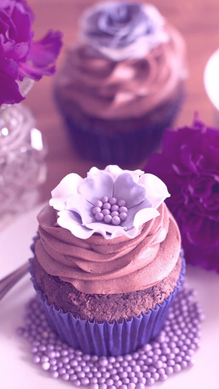 A cupcake with chocolate frosting and a flower on top. - Cupcakes