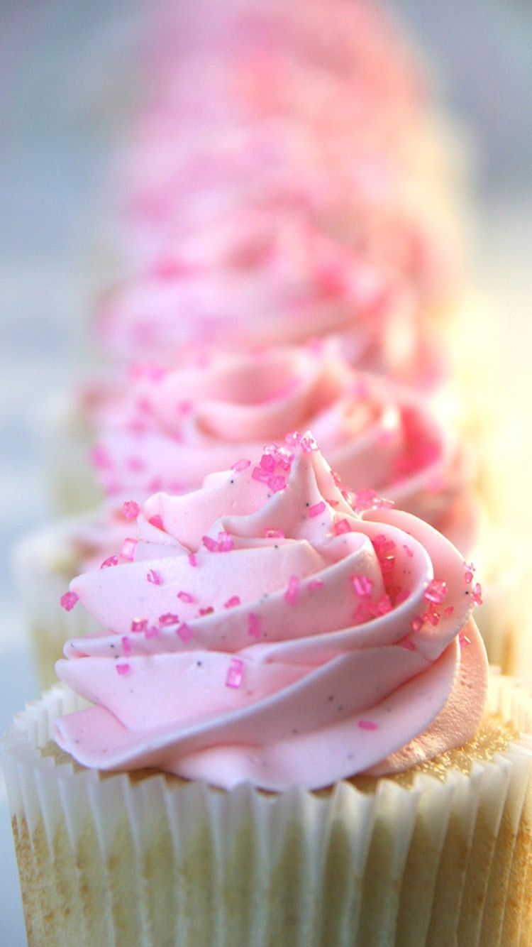A row of cupcakes with pink frosting and sprinkles. - Cupcakes