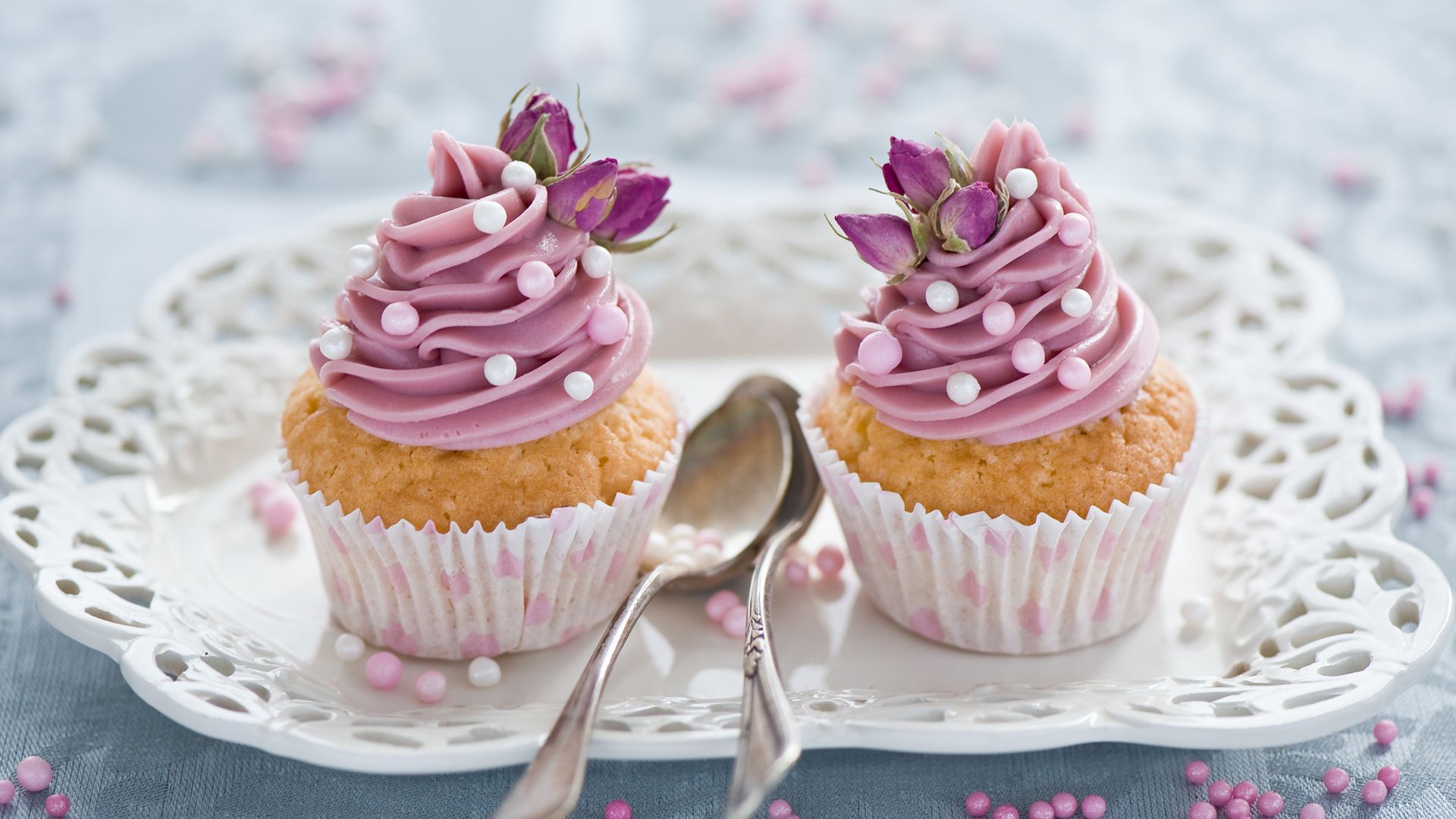 Two cupcakes with pink frosting on a white plate - Cupcakes