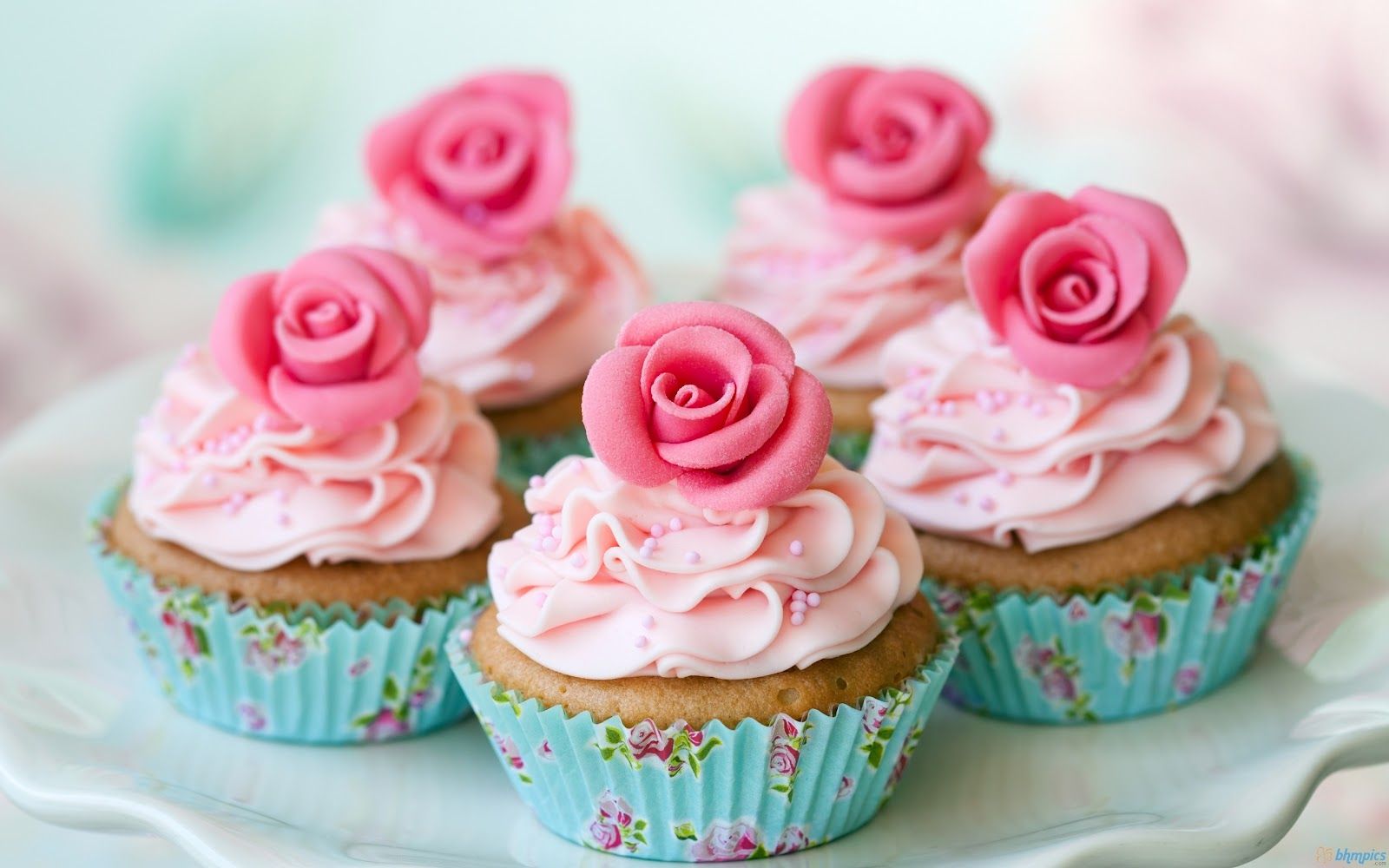 A plate of cupcakes with pink frosting and roses - Cupcakes