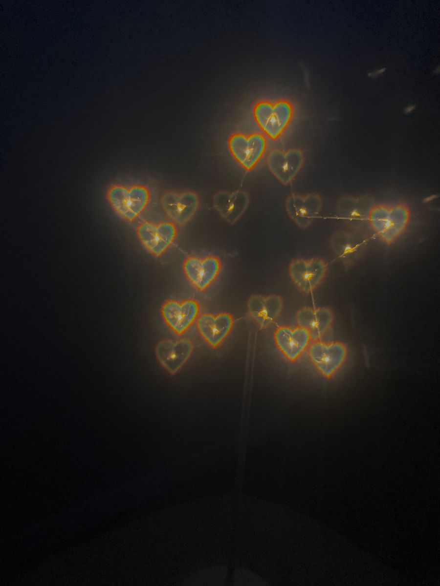 A dark background with a star shape created by string lights. - Lovecore