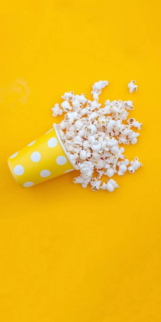 A cup of popcorn on a yellow background - Popcorn