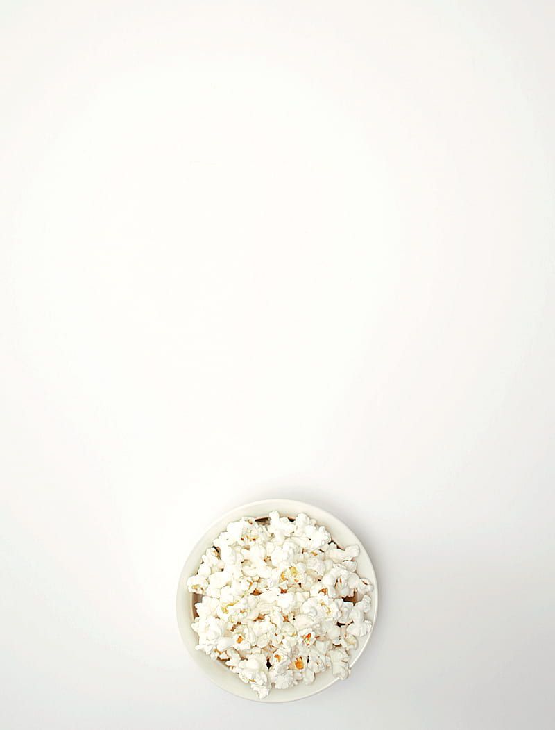 A bowl of popcorn sitting on top an empty plate - Popcorn