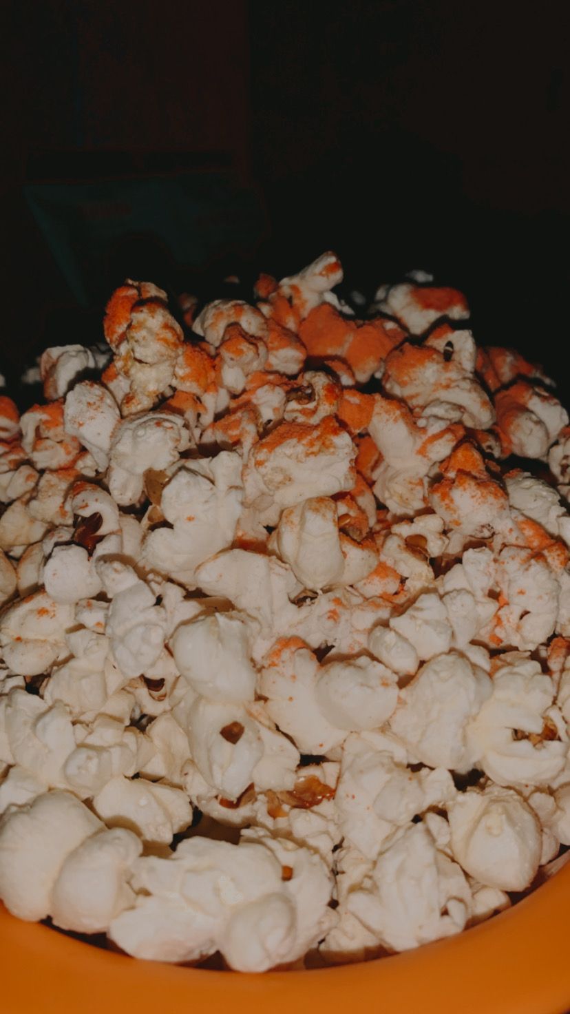 A bowl of popcorn sits on a table. - Popcorn