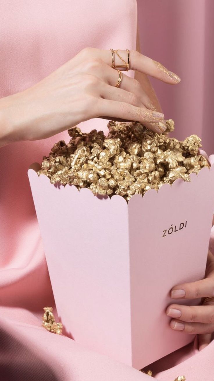 A woman in pink holding up some popcorn - Popcorn