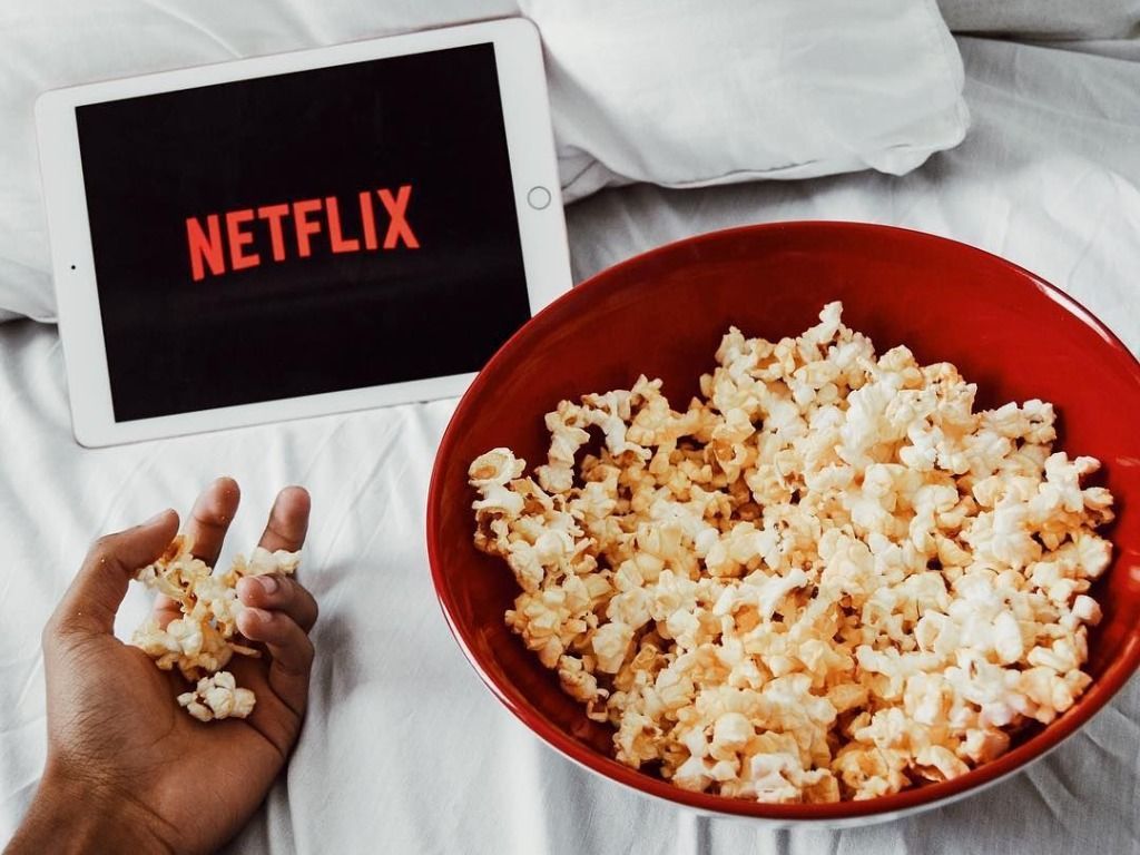 A bowl of popcorn and an iPad with the Netflix logo on it. - Popcorn, Netflix