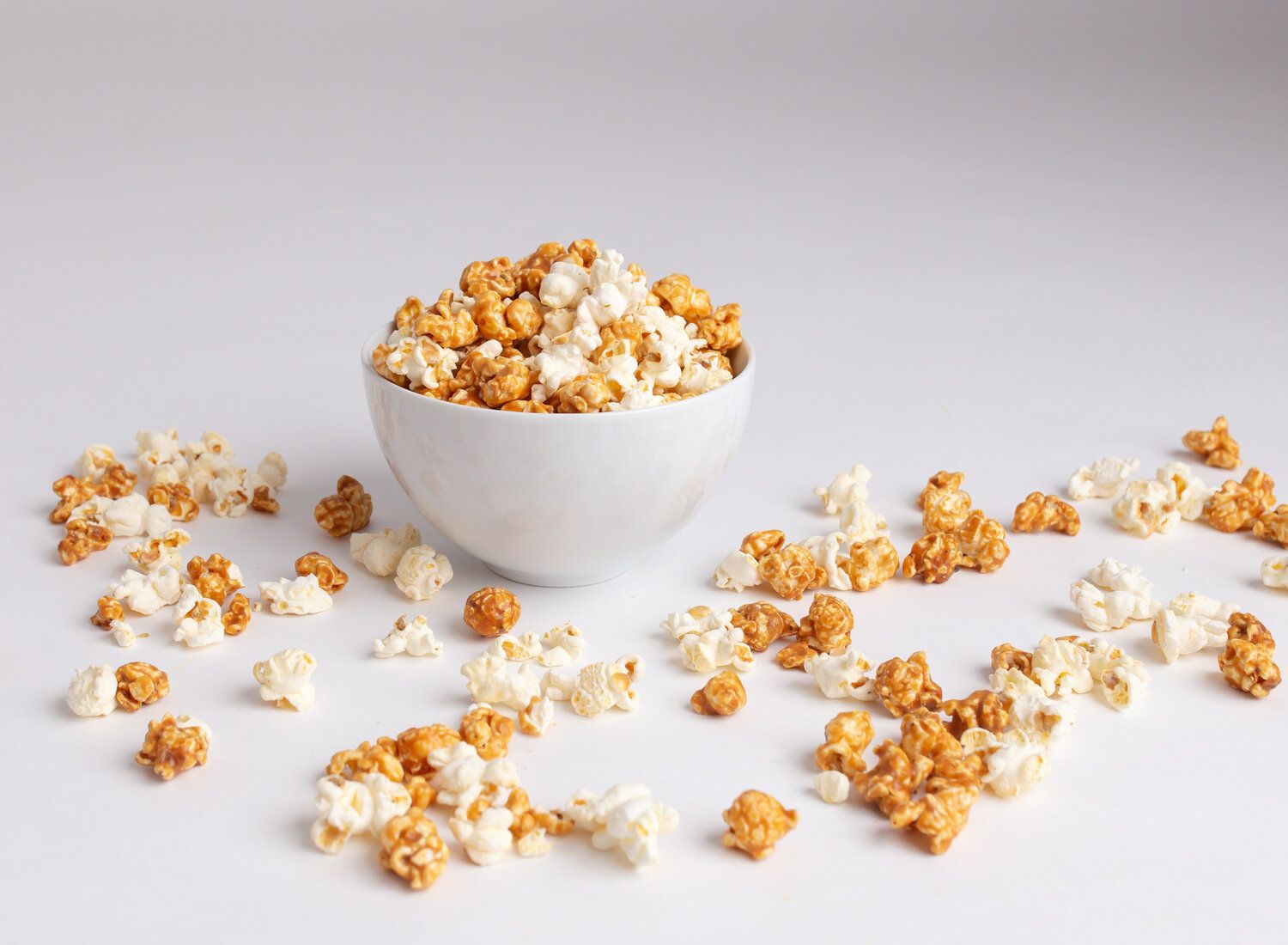 A bowl of popcorn on a white table - Popcorn