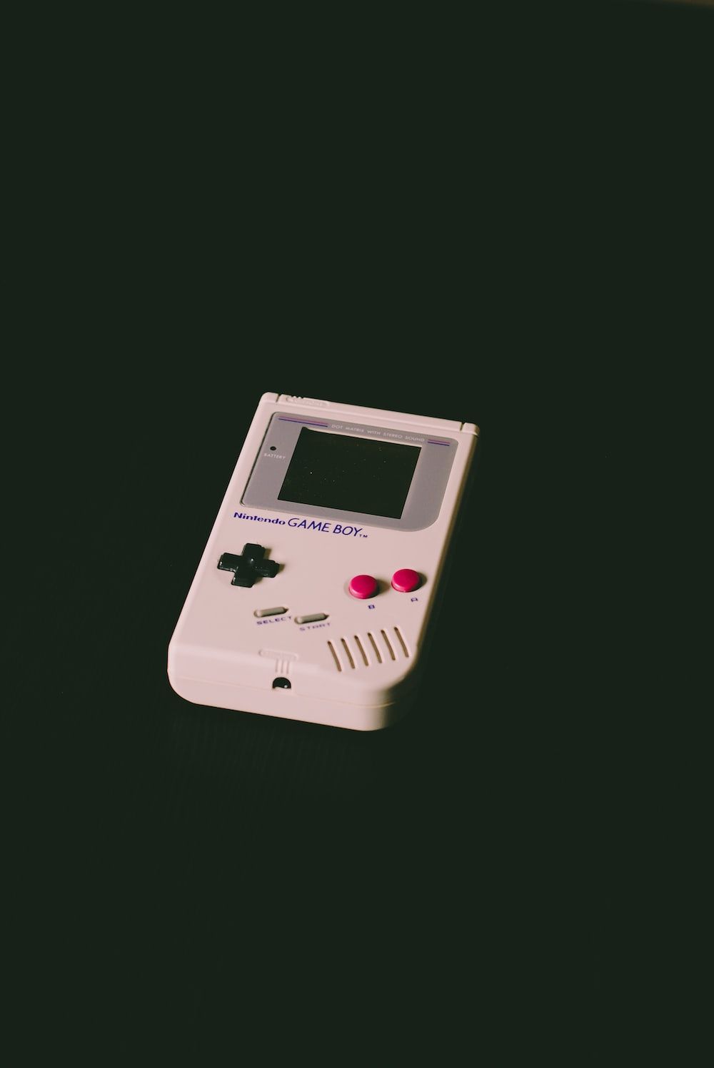 A small game boy is sitting on the table - Nintendo, Game Boy