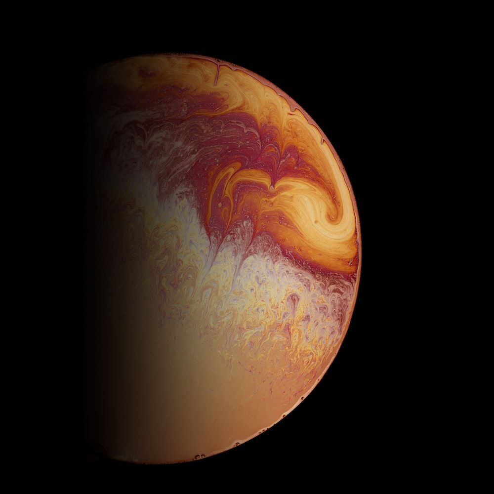 A planet-like sphere with a mix of orange, red, and yellow colors against a black background - Mars