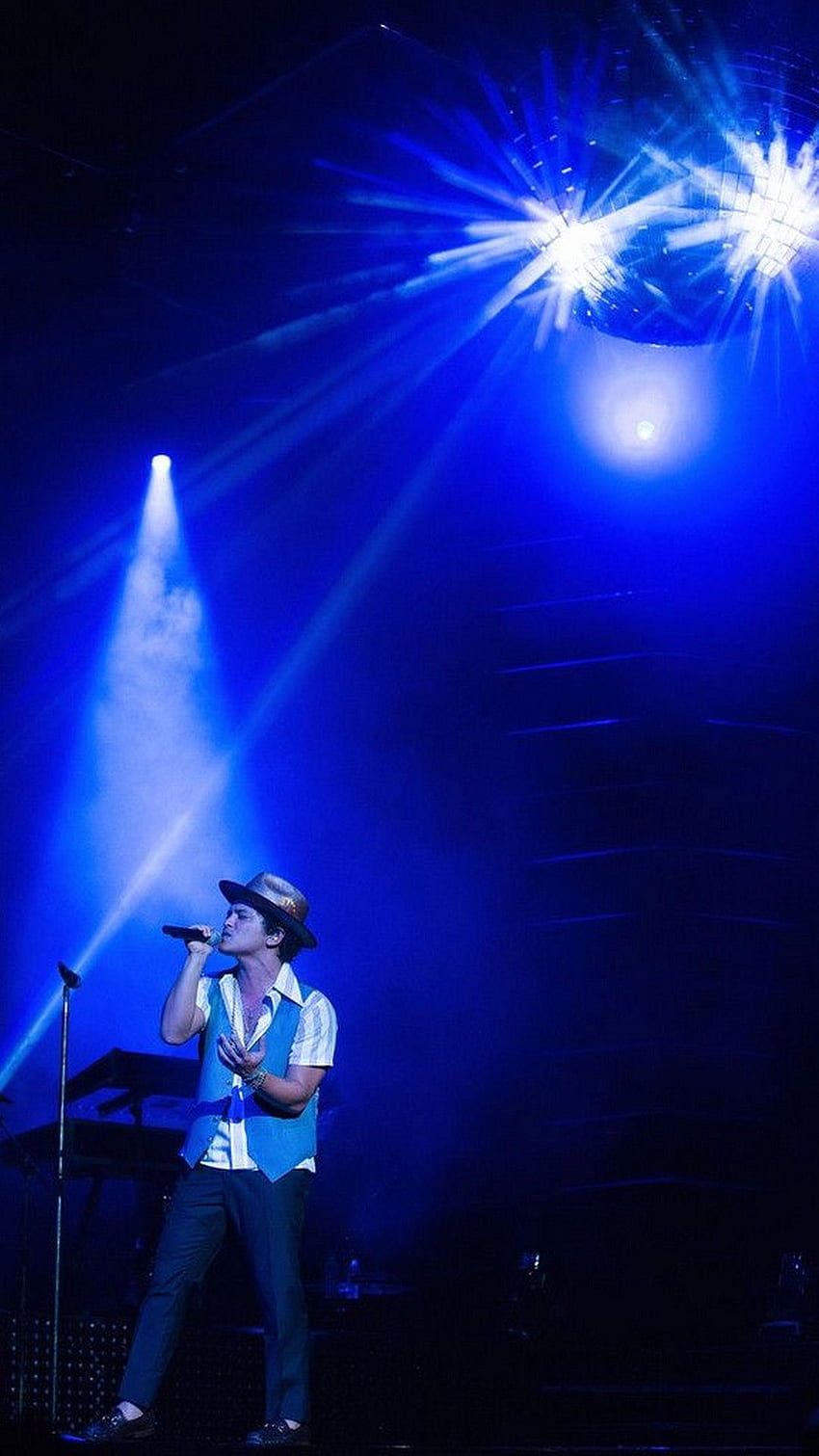 A man singing on stage with blue lights - Bruno Mars