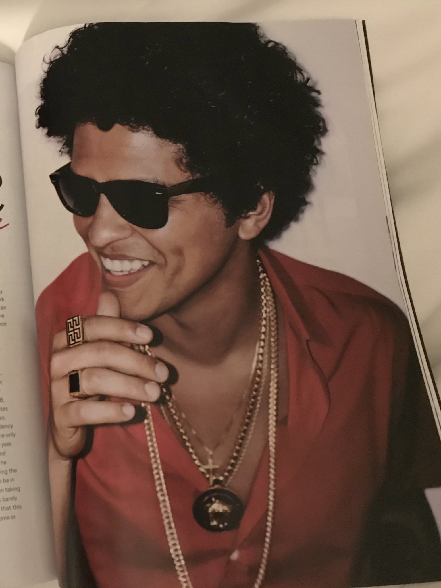 Bruno Mars is smiling and wearing a red shirt and sunglasses in a magazine - Bruno Mars