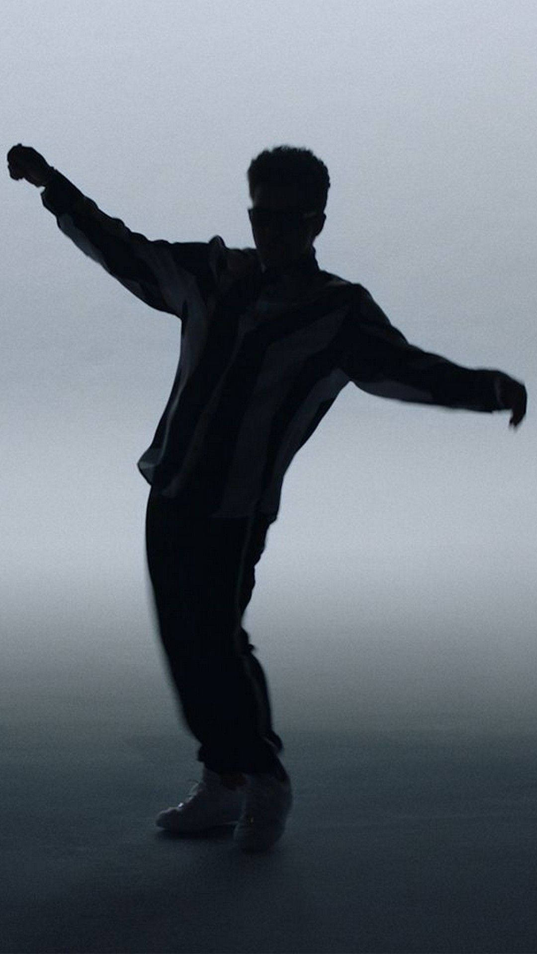 IPhone wallpaper of a silhouette of a man dancing in a foggy room - Bruno Mars