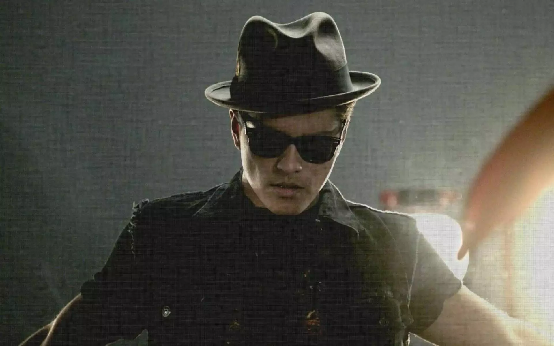 A man in hat and sunglasses with an umbrella - Bruno Mars