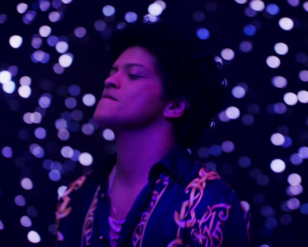 A man in black shirt and blue jacket looking up - Bruno Mars