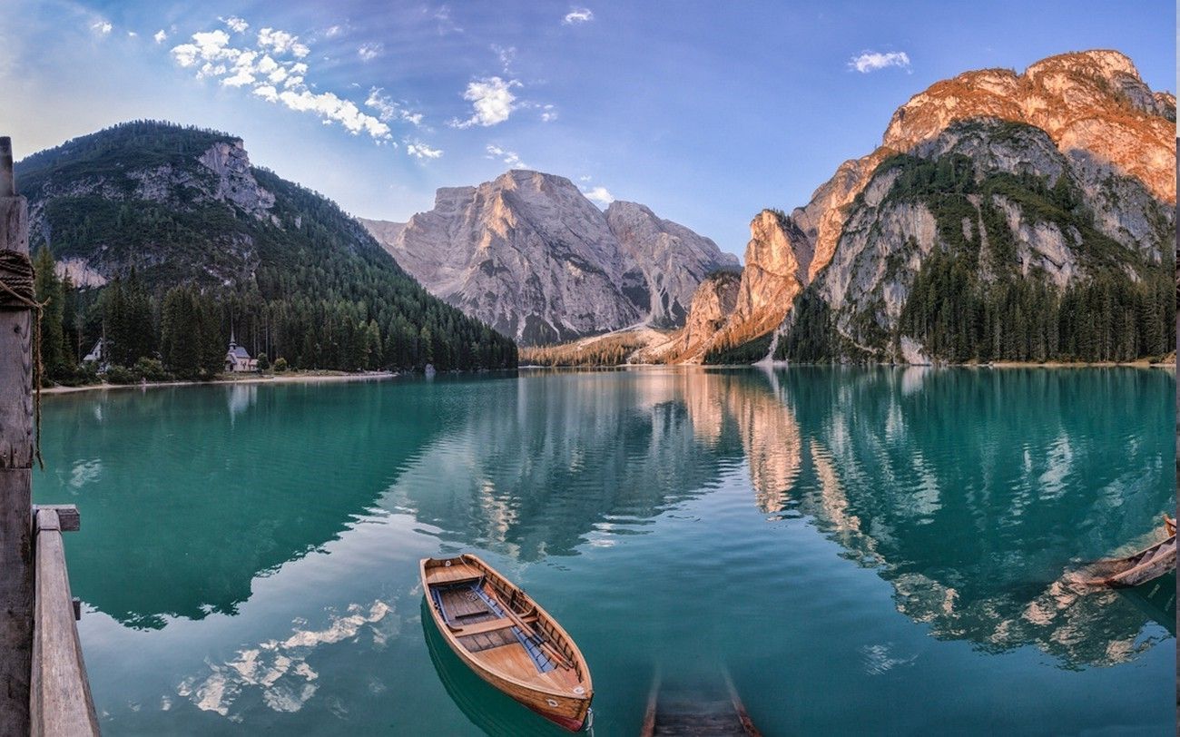 A boat in a lake surrounded by mountains - Lake