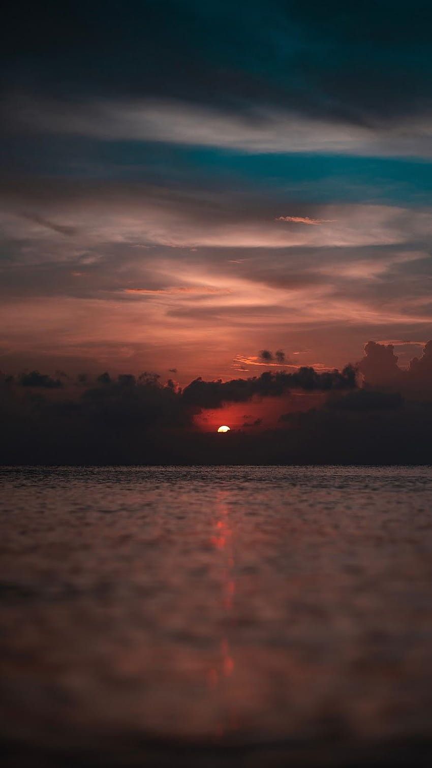 A photo of the sun setting over the ocean - Lake