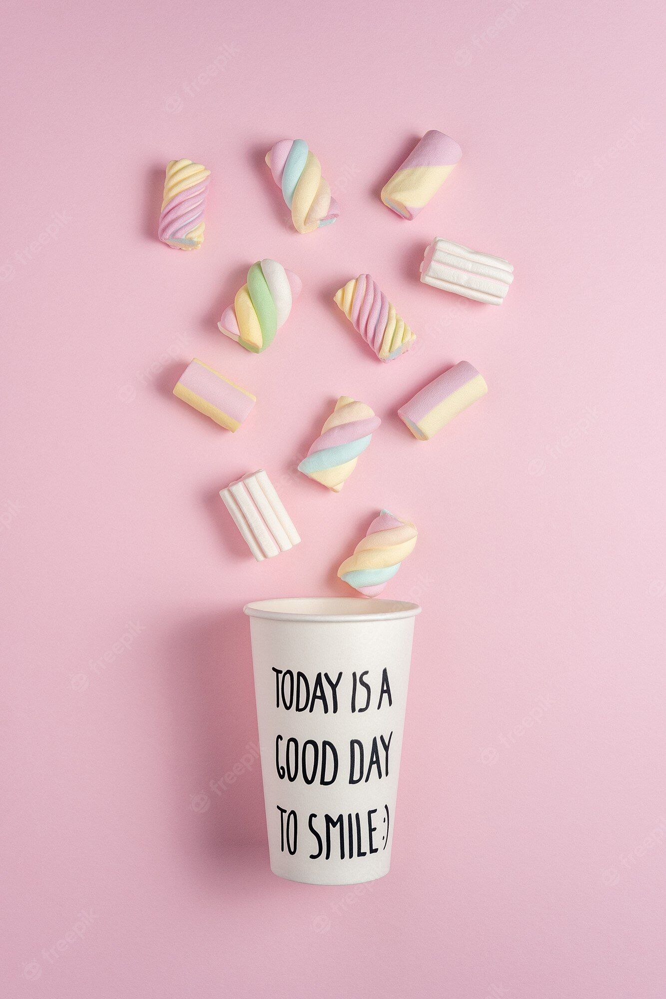 Premium Photo. Colorful marshmallows with paper cup on pink background