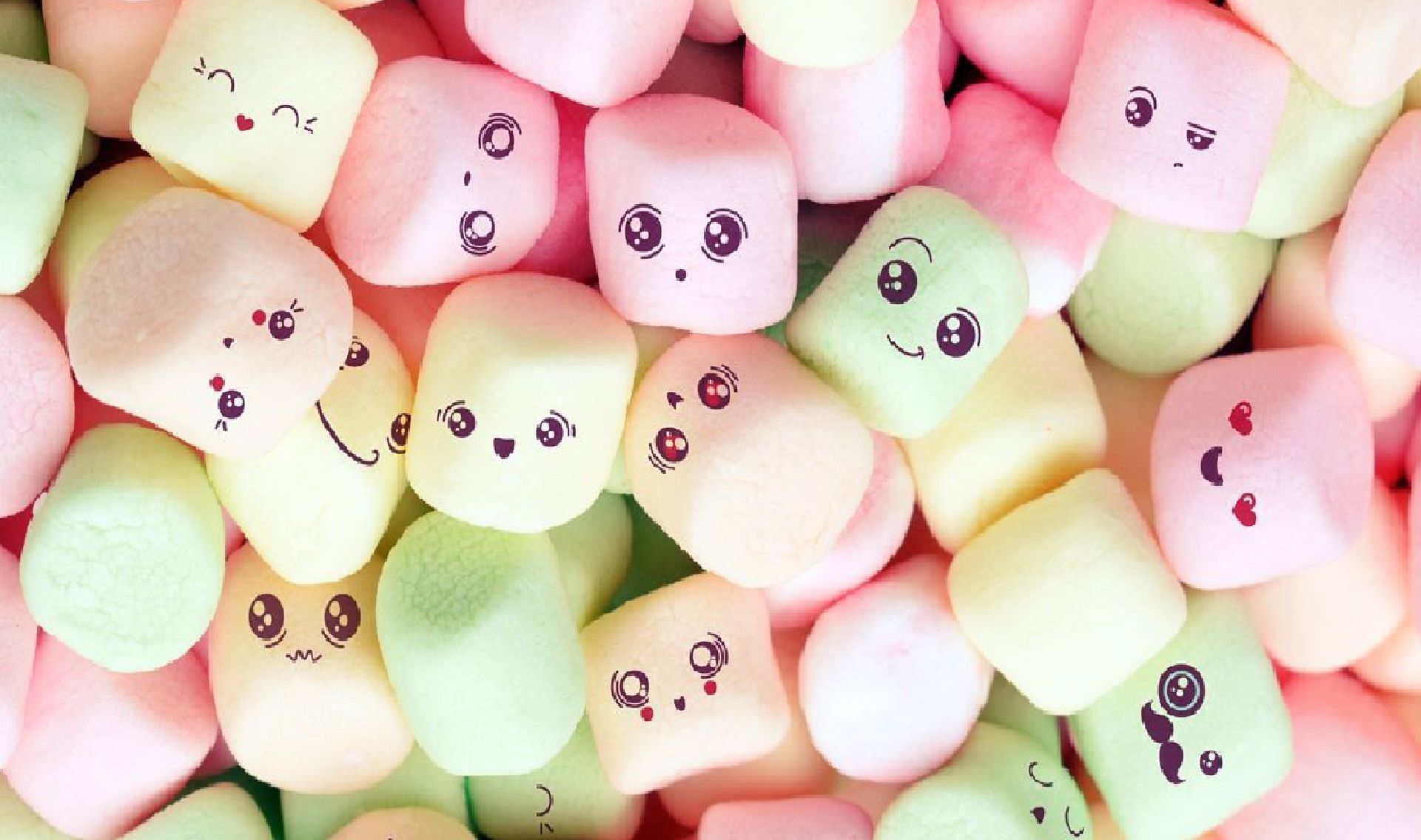 A pile of marshmallows with cute faces drawn on them. - Marshmallows