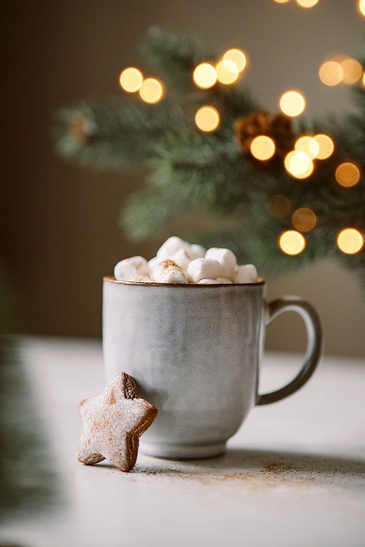 A mug of hot chocolate with marshmallows and a gingerbread star. - Marshmallows