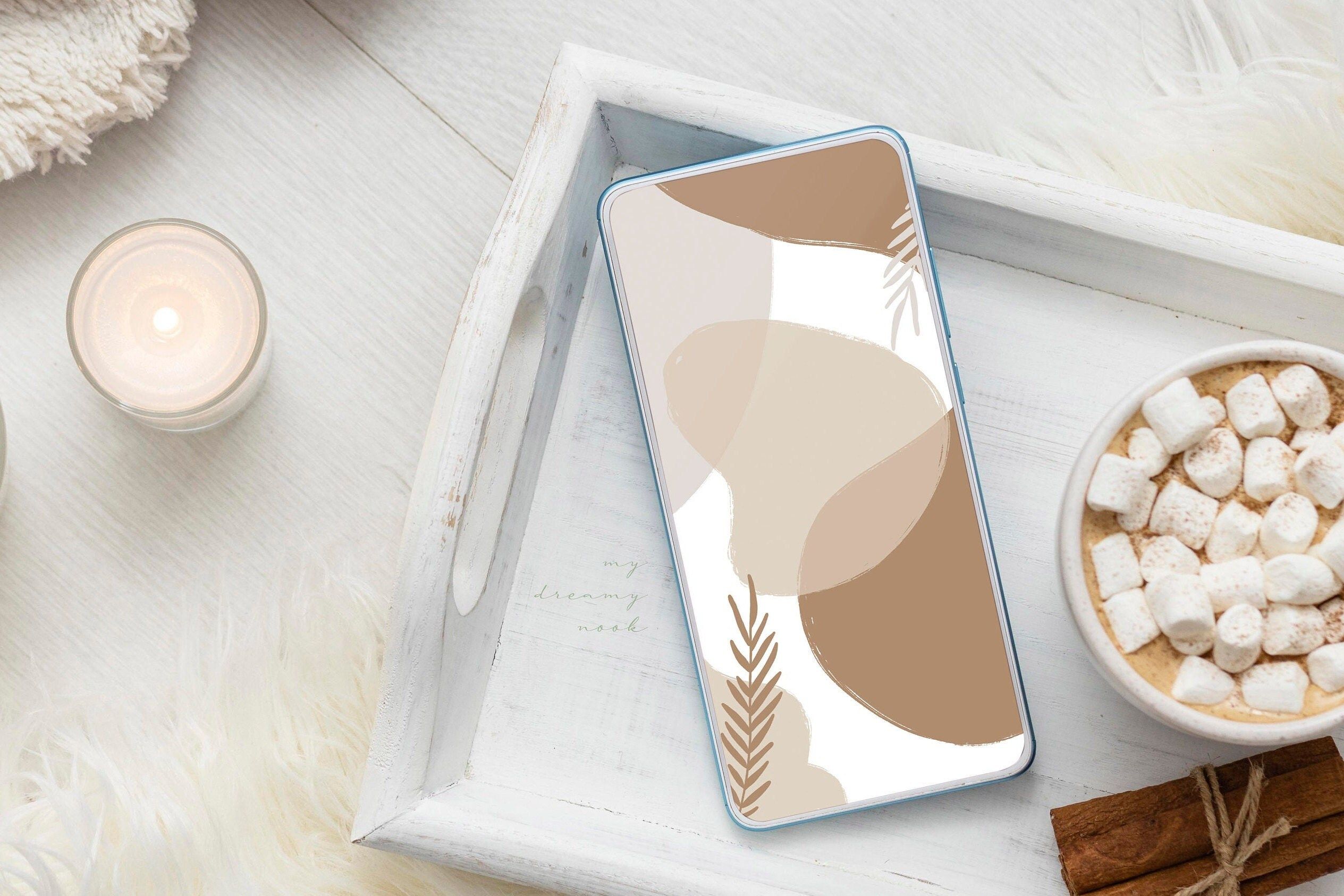 A phone with a digital wallpaper of a minimalist desert design on the screen. - Marshmallows