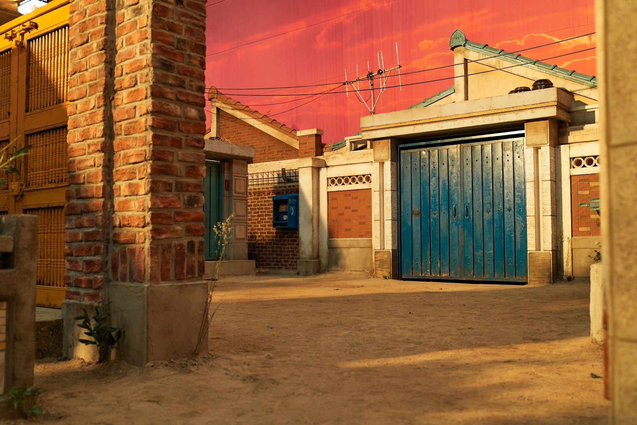 A building with blue doors and red sky - Squid Game